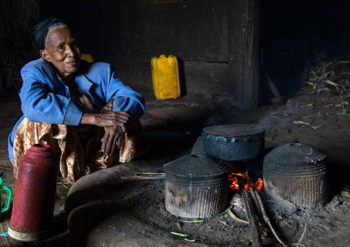 Gurage woman inside her traditional house in front of the fireplace, Gurage Zone, Butajira, Ethiopia