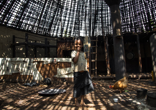 Girl under a Gurage traditional roof without thatch in renovation, Gurage Zone, Butajira, Ethiopia