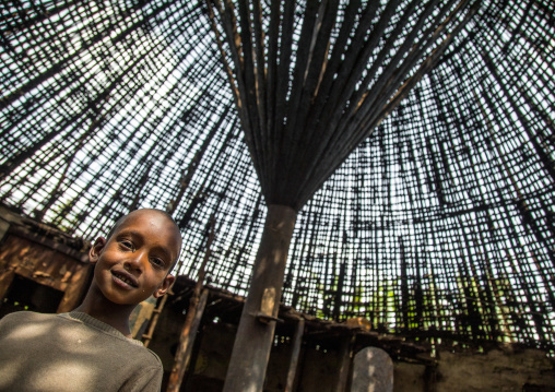 Boy under a Gurage traditional roof without thatch in renovation, Gurage Zone, Butajira, Ethiopia