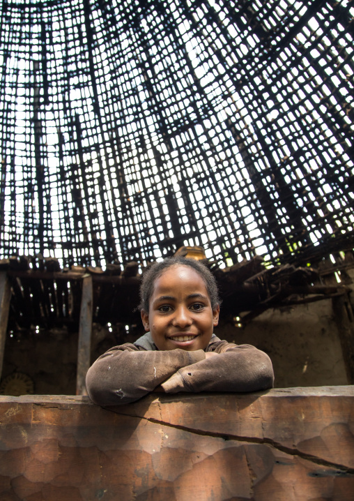 Girl under a Gurage traditional roof without thatch in renovation, Gurage Zone, Butajira, Ethiopia