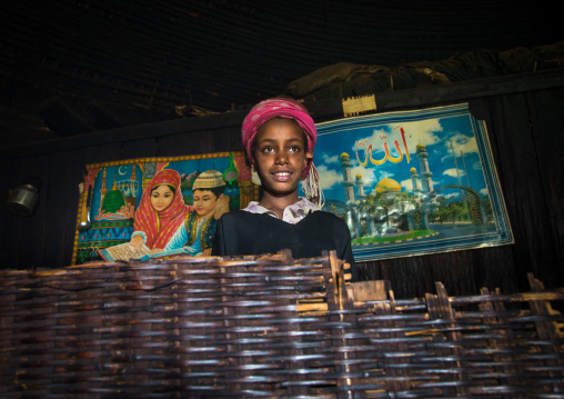 Gurage girl inside her traditional house decorated with muslim posters on the walls, Gurage Zone, Butajira, Ethiopia