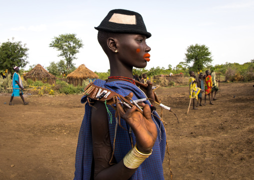 Beautiful young woman with a hat and some make up during the fat men ceremony in the Bodi tribe, Omo valley, Hana Mursi, Ethiopia