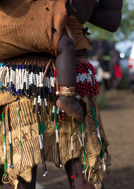 Woman carrying her baby during the fat men ceremony in Bodi tribe, Omo valley, Hana Mursi, Ethiopia