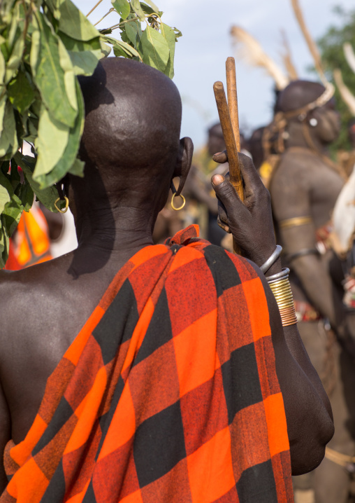 Woman protecting from the sun with leaves during the fat men ceremony in Bodi tribe, Omo valley, Hana Mursi, Ethiopia