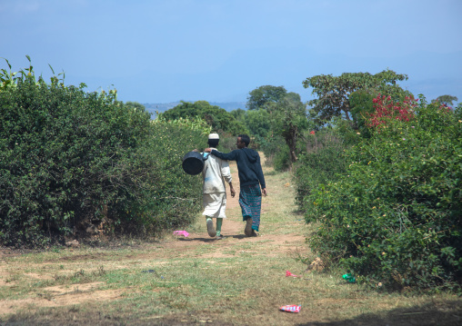 Muslim friends walking together in the countryside, Harari Region, Harar, Ethiopia