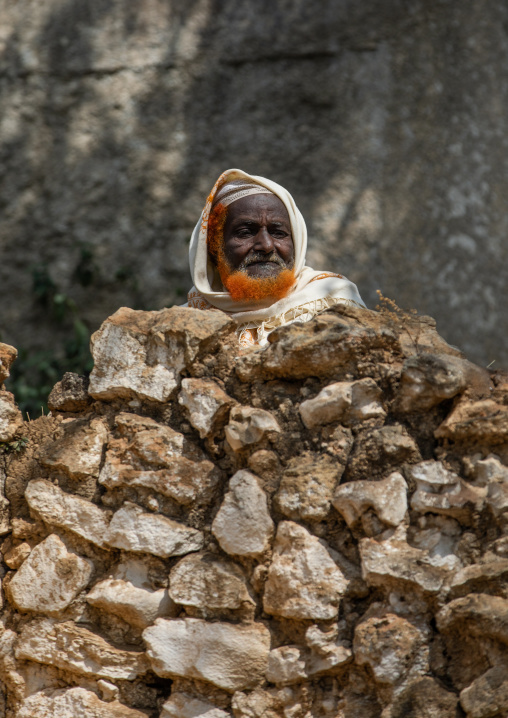 Harari man with a red beard being a stones wall, Harari Region, Harar, Ethiopia