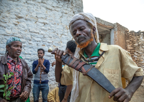 Harari man dancing with a huge knife during a sufi celebration, Harari Region, Harar, Ethiopia