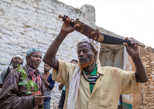 Harari man dancing with a huge knife during a sufi celebration, Harari Region, Harar, Ethiopia
