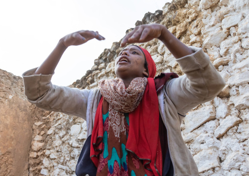 Sufi woman with a red veil into trance during a muslim ceremony, Harari Region, Harar, Ethiopia