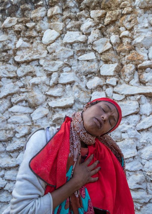 Sufi woman with a red veil into trance during a muslim ceremony, Harari Region, Harar, Ethiopia