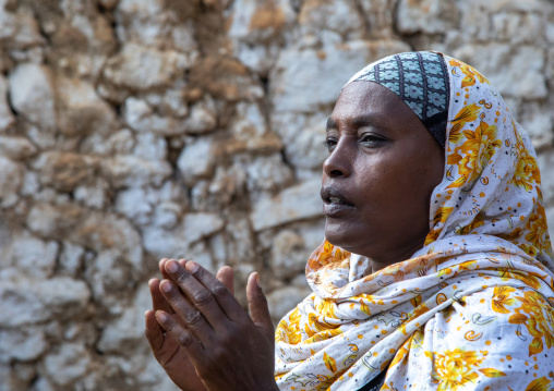Veiled harari woman clapping her hands during a sufi ceremony, Harari Region, Harar, Ethiopia