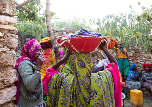 Harari women bringing injeras in baskets on their heads for a muslim celebration, Harari Region, Harar, Ethiopia
