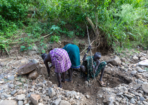 Suri tribe girls doing gold panning in a river, Omo valley, Kibish, Ethiopia