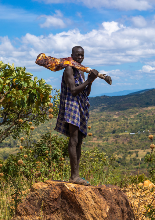 Suri man carrying meat on his shoulder, Omo valley, Kibish, Ethiopia