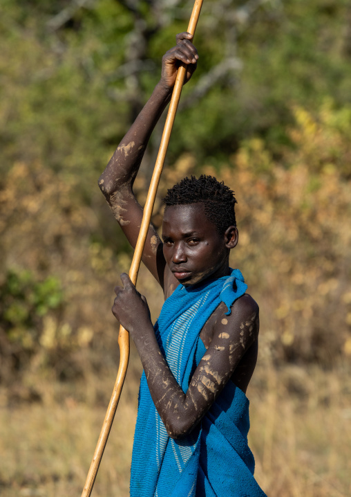 Suri tribe boy with a stick during a donga ritual, Omo valley, Kibish, Ethiopia