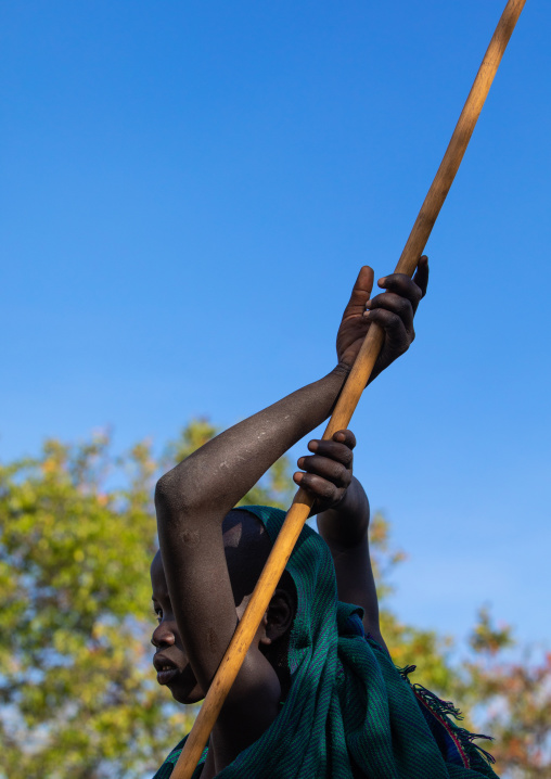 Suri tribe boy with a stick during a donga ritual, Omo valley, Kibish, Ethiopia