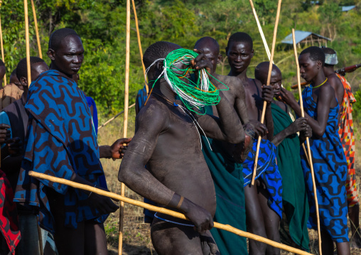 Suri tribe warrior wearing necklaces offered by women during a donga stick fighting ritual, Omo valley, Kibish, Ethiopia