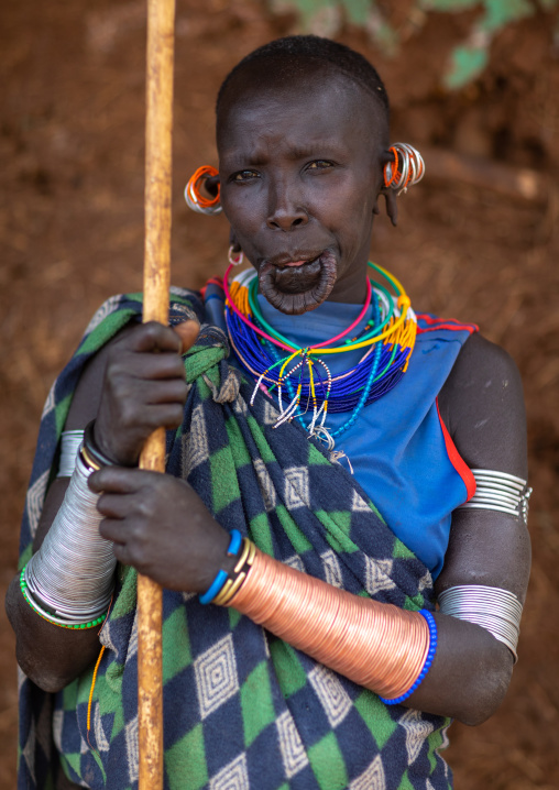 Portrait of a  suri tribe woman with impressive bracelets and a huge lower lip, Omo valley, Kibish, Ethiopia