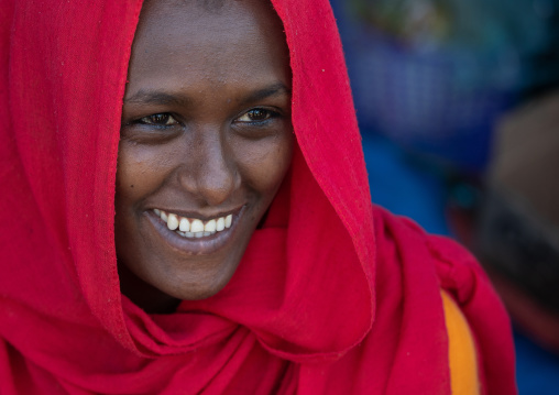Smiling oromo teenage girl wearing a red veil, Amhara region, Senbete, Ethiopia