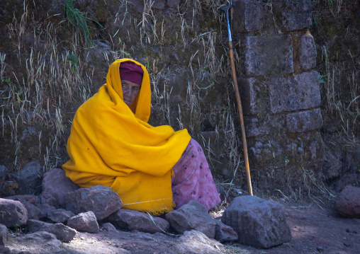 Lonely ethiopian monk woman in yellow shawl, Amhara Region, Lalibela, Ethiopia