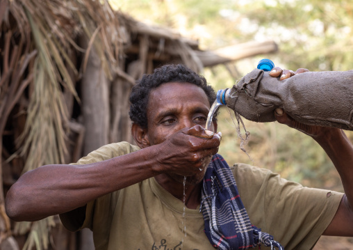 Afar tribe man drinking water, Afar Region, Afambo, Ethiopia