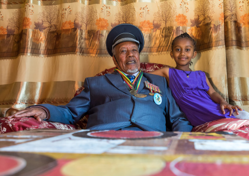 Ethiopian veteran from the italo-ethiopian war in army uniform with his young daughter, Addis Ababa Region, Addis Ababa, Ethiopia