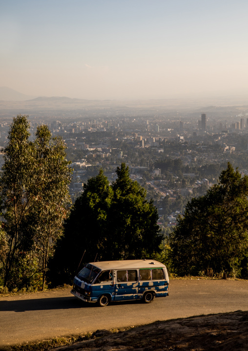 Bus passing in front of a panoramic view of the town seen from Entoto mountain, Addis Ababa Region, Addis Ababa, Ethiopia