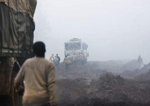 People Going Back To A Bus Pulled Out From The Muddy Path Of A Construction Site, Hossana, Omo Valley, Ethiopia