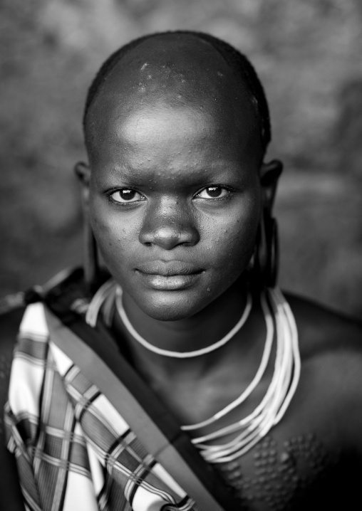 Suri tribe teenage girl with enlarged earlobe, Kibish, Omo valley, Ethiopia
