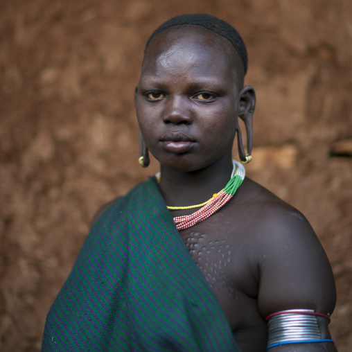 Suri tribe girl with enlarged earlobes, Kibish,  Omo valley, Ethiopia