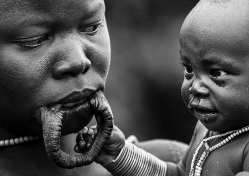 Suri tribe woman with enlarged lip and her baby, Kibish, Omo valley, Ethiopia