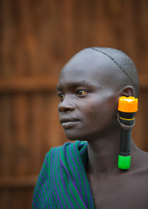 Suri tribe man with an enlarged ear decorated with a lamp, Kibish, Omo valley, Ethiopia