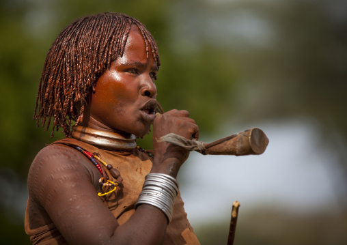 Hamar Tribe Woman With Traditional Hairstyle  Blowing A Trumpet At Bull Jumping Ceremony, Turmi, Omo Valley, Ethiopia