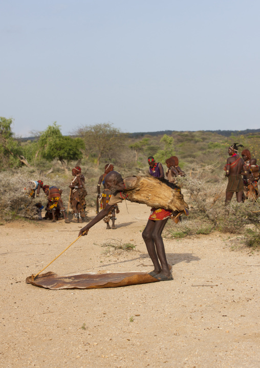 Hamar Tribe Man Laying Down An Animal Skin For His Son To Lay Down To Receive A Benediction From The Eleders Before Bull-jumping, Turmi, Omo Valley, Ethiopia