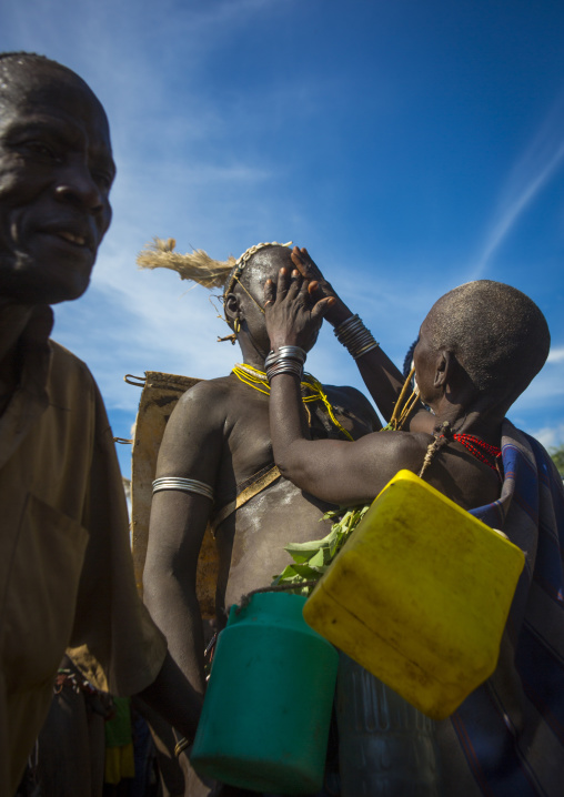 Bodi Tribe Woman Putting Water On The Face Of A Fat Man During Kael Ceremony, Hana Mursi, Omo Valley, Ethiopia