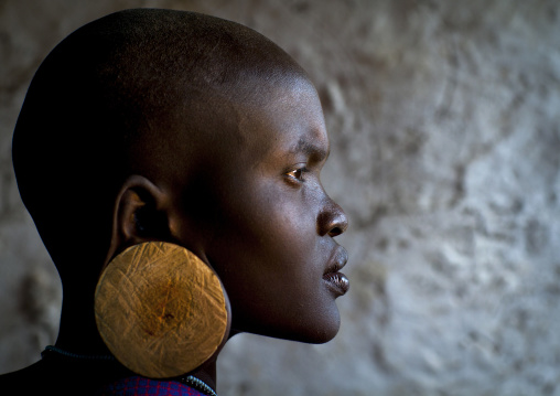 Portrait Of A Young Mursi Tribe Woman With Enlarged Ear In Mago National Park, Omo Valley, Ethiopia