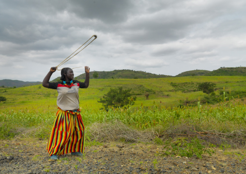 Konso Woman Mixed Ethnic Western Style Clothing Is Using A Slingshot Amidst Field Omo Valley Ethiopia