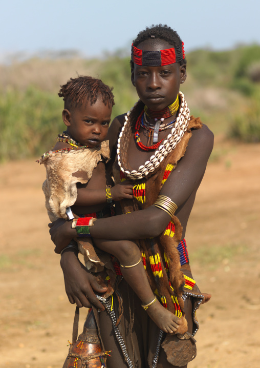 Hamer Mother With Beaded Headband Carrying Little Boy Wearing Skin Ethiopia