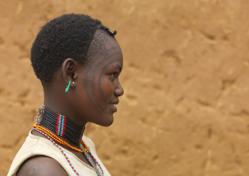 Profile portrait of a tsemay tribe tattooed face woman, Omo valley, Ethiopia