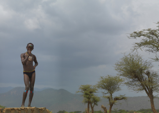 Teenage tsemay tribe boy standing in a bathing suit, Omo valley, Ethiopia