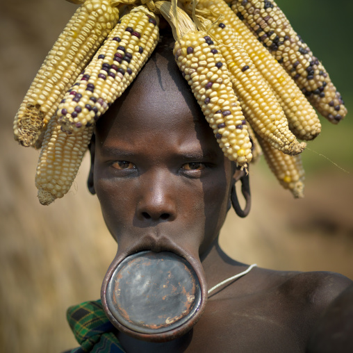 Young Mursi Woman With Corn Cob Headdress And Black Clay Plate In Inferior Lip, Ethiopia