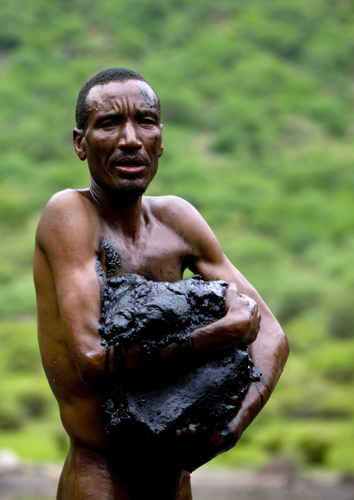 Borana Tribe Man Getting Out Of The Crater Lake Of El Sod Volcano With Volcanic Mud In The Arms, Omo Valley, Ethiopia