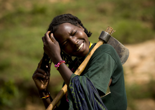 Portrait Of A Young Borana Tribe Lumberjack Woman Tidying Her Hair And Carrying An Axe, Yabello, Yabello, Omo Valley, Ethiopia