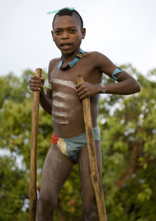 Portrait Of A Banna Tribe Kid With Body Painting Walking On Stilts Turmi, Omo Valley, Ethiopia