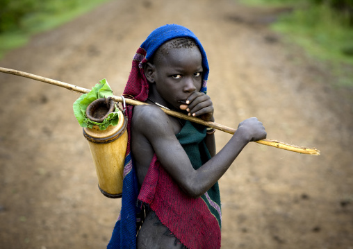 Portrait Of A Bodi Tribe Boy Going To Sell Milk At Hana Mursi Market, Omo Valley, Ethiopia
