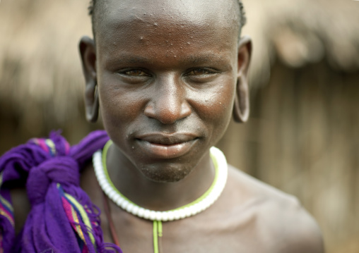 Young surma man with extended ear lobes, Tulgit, Omo valley, Ethiopia