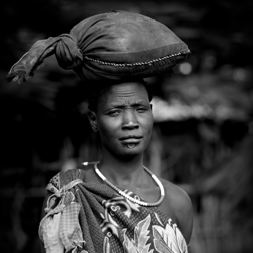 Black And White Portrait Of A Bodi Tribe Woman Carrying A Bag On Her Head, Hana Mursi, Omo Valley, Ethiopia