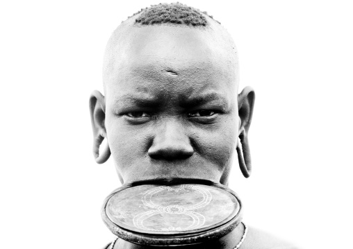 Black And White Portrait Of A Mursi Tribe Woman With Lip Plate And Extended Ear Lobes, Omo Valley, Ethiopia
