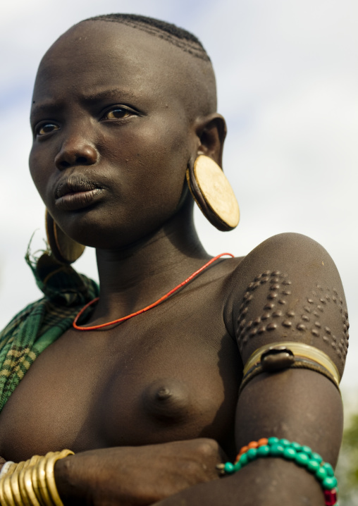 Portrait Of A Mursi Tribe Woman With Ear Plates And Scarifications, Omo Valley Ethiopia