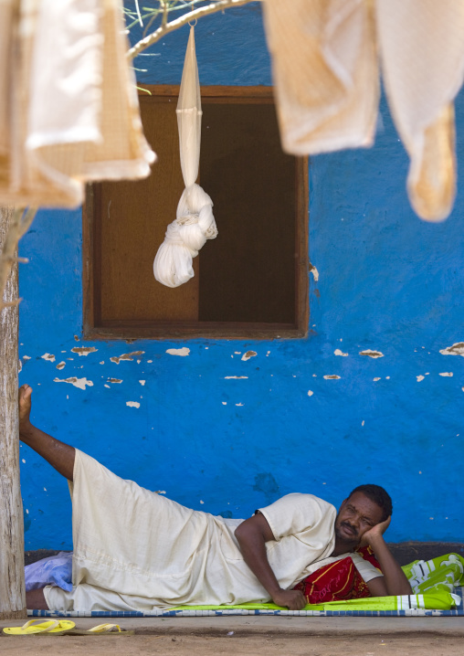 Man resting in a blue painted hotel in omorate, Ethiopia